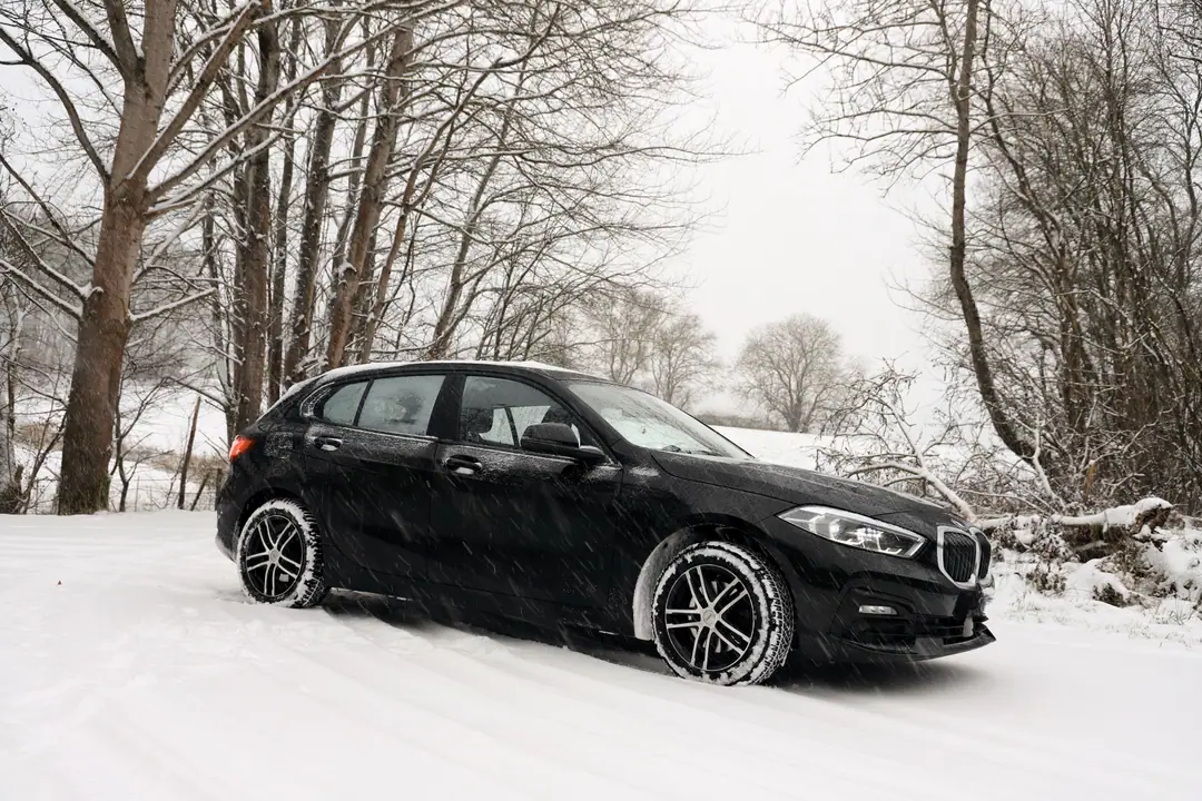 Voiture équipée de pneus hiver sur une route de montagne enneigée